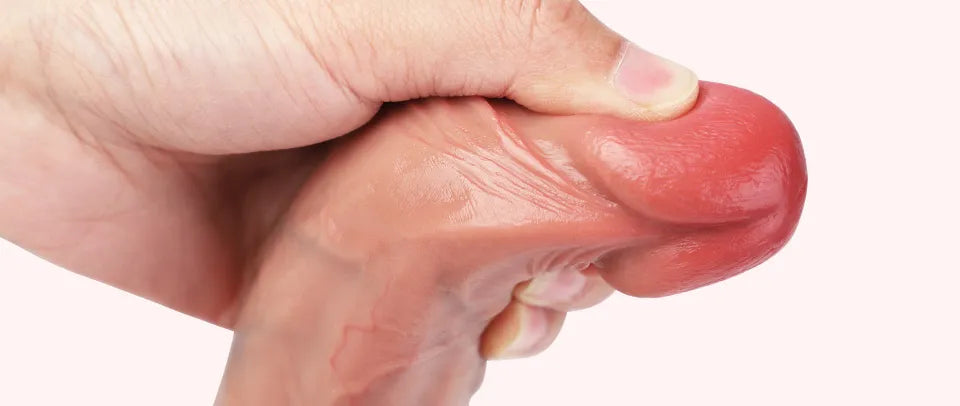 Close-up of Elon realistic dildo tip being squeezed by hand