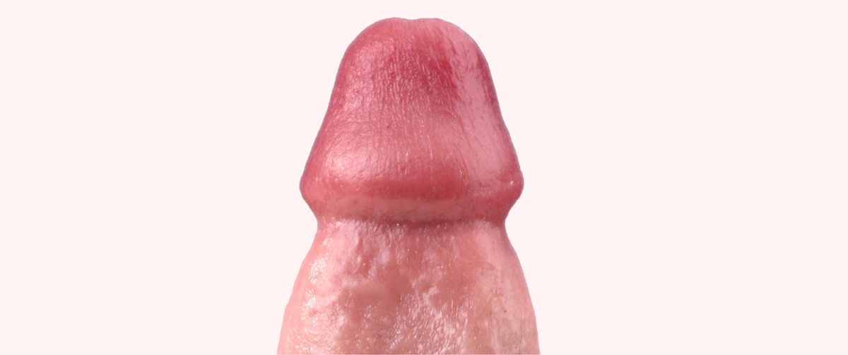 Close-up of the Don realistic dildo’s rounded tip and lifelike textured shaft on a pale pink background.