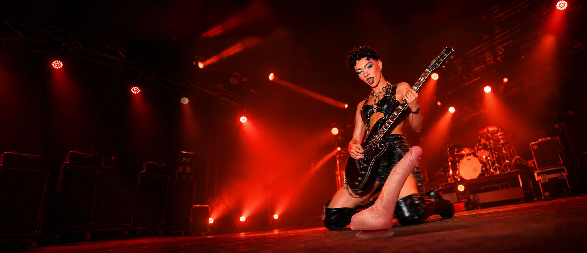 Jessie realistic platinum silicone dildo with guitarist performing under red stage lights