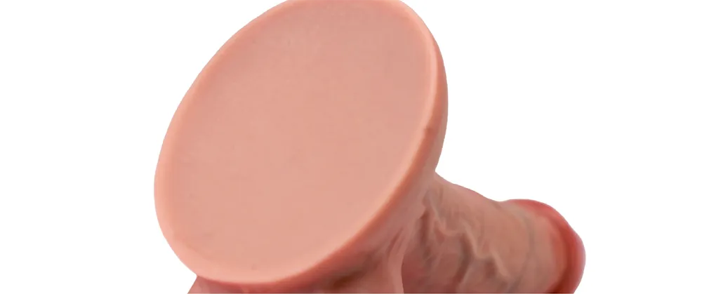 Close-up of the Coach dildo’s flat suction-cup base and textured flesh-toned shaft.